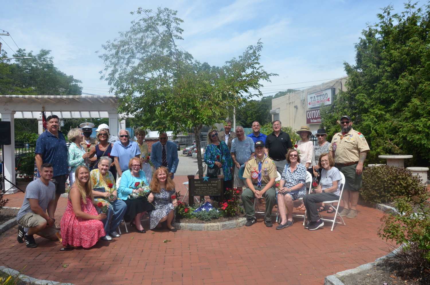 Members of the Moriches Bay Garden Club and friends and family of Steven Rosche gather around the newly dedicated Blue Star Memorial.