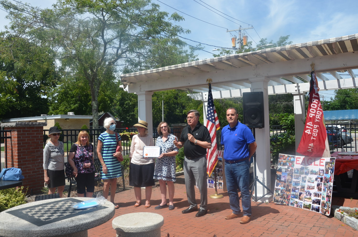 Brookhaven Town supervisor Ed Romaine (in black) and town councilman Dan Panico (in blue) present members of the Moriches Bay Garden Club with a citation.